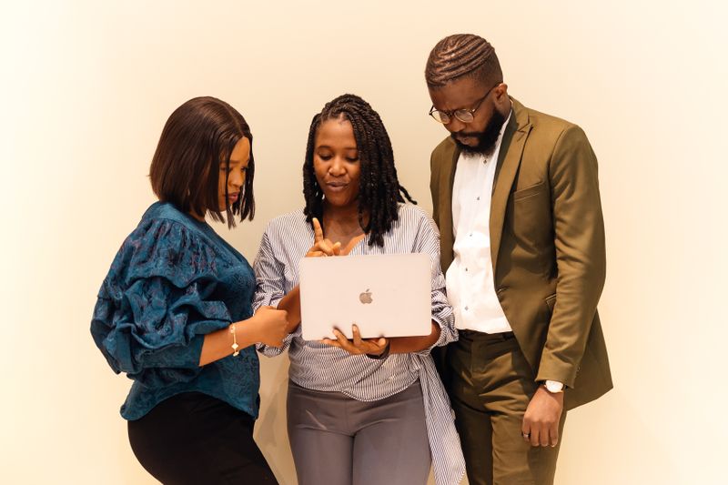 African business professionals collaborating around a laptop in a Lagos office meeting